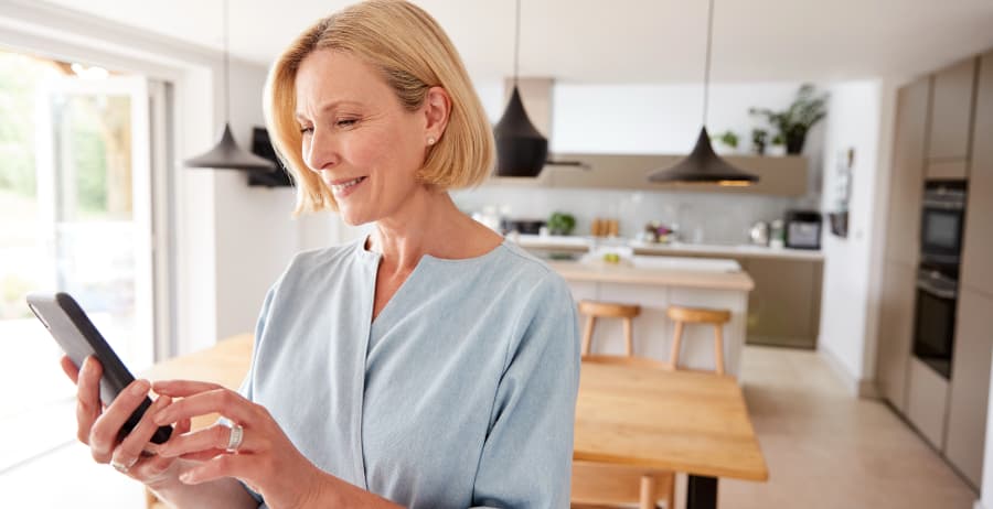 Woman holding a smartphone in a stylish home